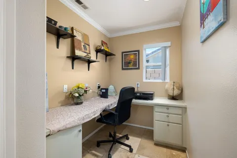 a view of a workspace with furniture and a window