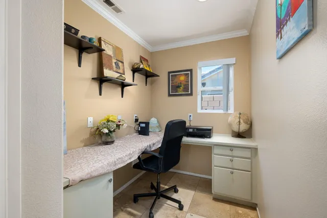 a view of a workspace with furniture and a window