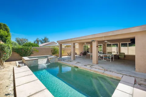 a swimming pool with outdoor seating and yard
