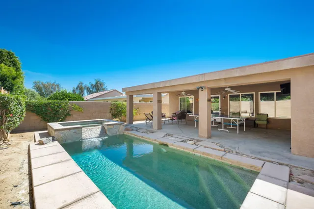 a swimming pool with outdoor seating and yard
