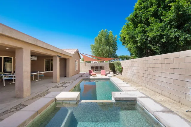 a view of a patio with couches table and chairs with wooden floor and fence