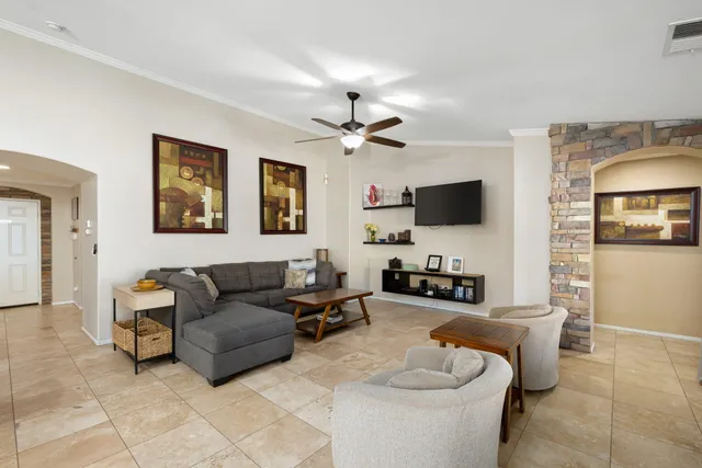 a living room with furniture a flat screen tv and kitchen view