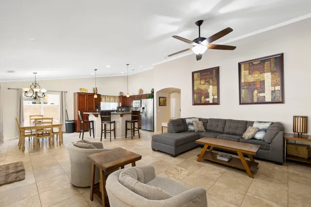 a living room with furniture kitchen view and a chandelier