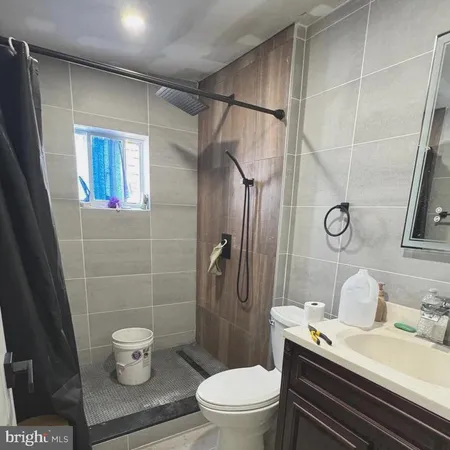 a white toilet sitting next to a bathroom sink and a shower