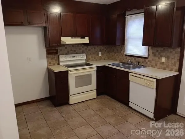 a kitchen with a stove sink and cabinets