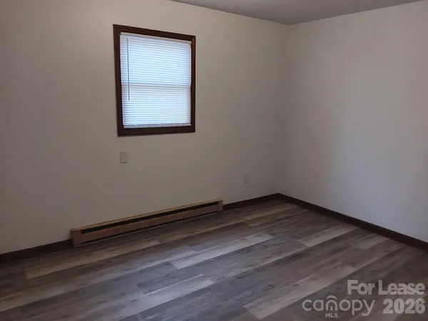 a view of a small space with wooden floor and a window