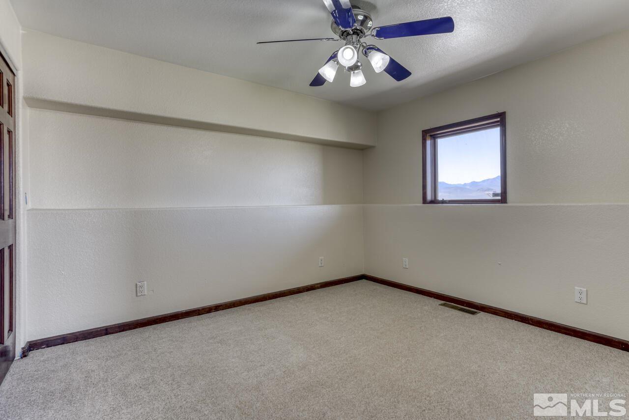 650 Desert Shadows Lane Fernley, NV 89408 - Photo 19 of 39 an empty room with a window and a fan