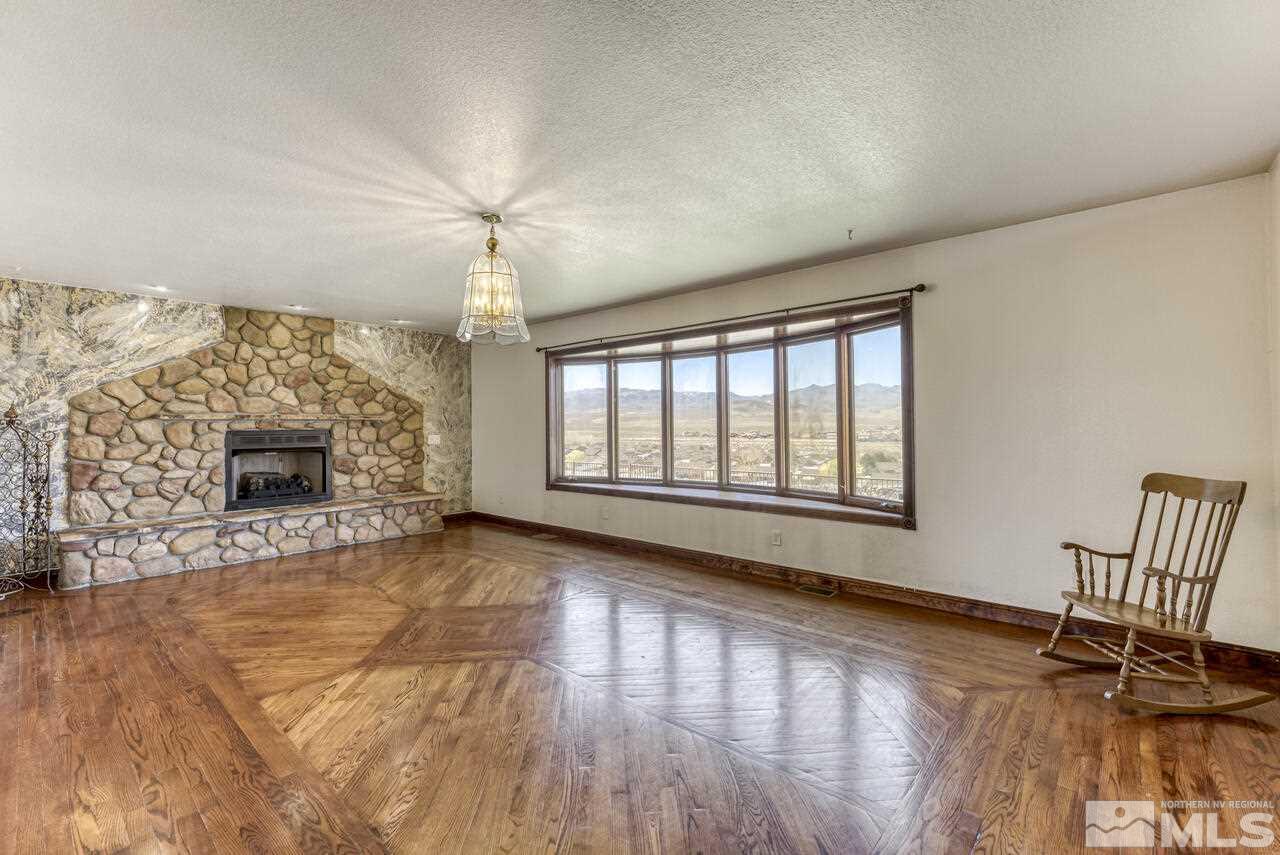 650 Desert Shadows Lane Fernley, NV 89408 - Photo 26 of 39 a view of a livingroom with a fireplace a ceiling fan and wooden floor