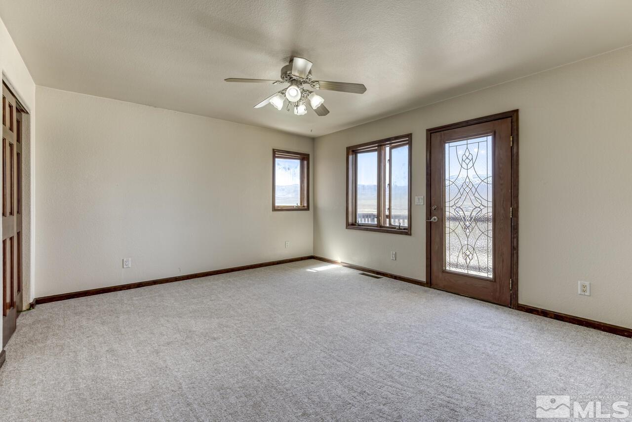 650 Desert Shadows Lane Fernley, NV 89408 - Photo 27 of 39 an empty room with chandelier fan and windows