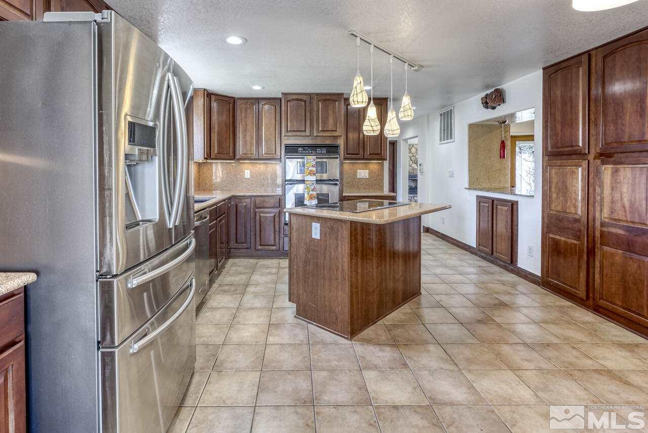 650 Desert Shadows Lane Fernley, NV 89408 - Photo 4 of 39 a kitchen with stainless steel appliances granite countertop a refrigerator and a stove