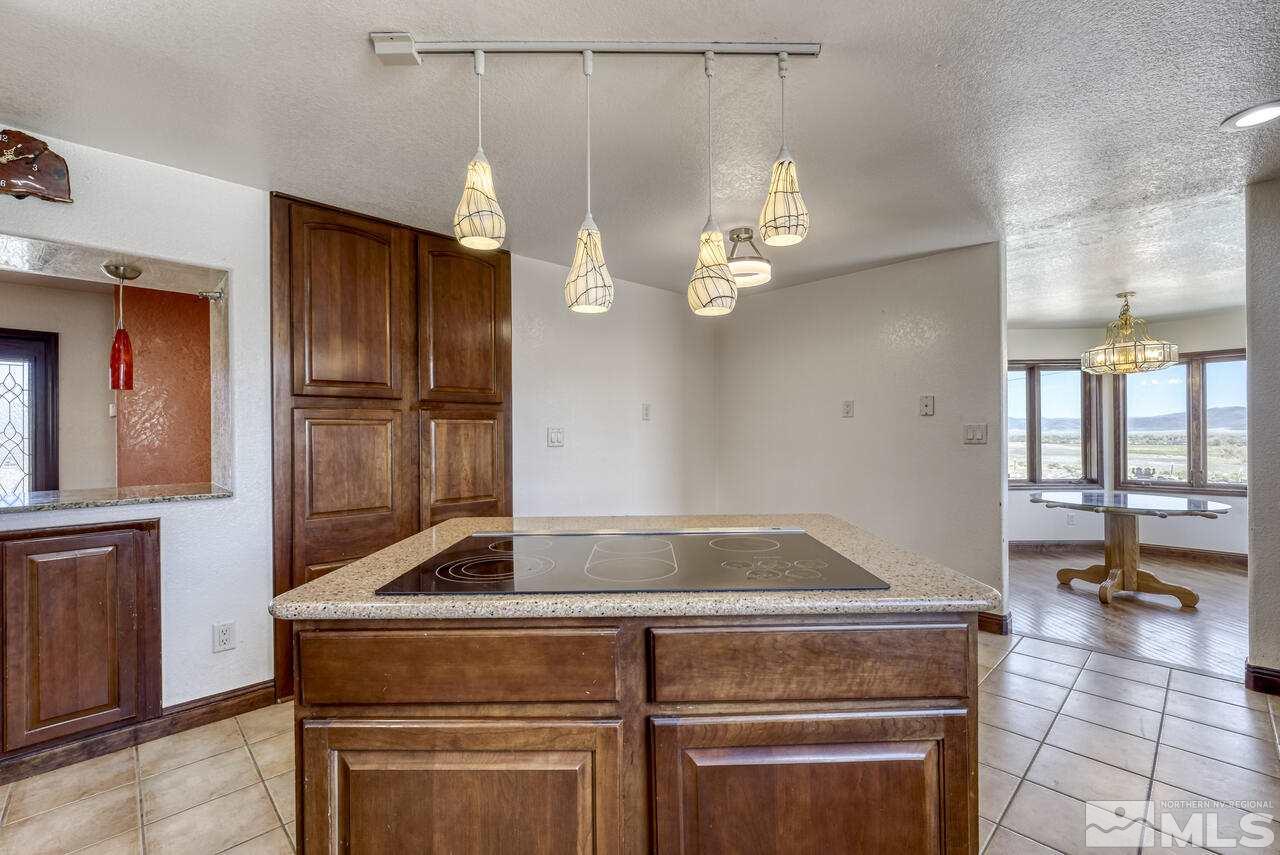 650 Desert Shadows Lane Fernley, NV 89408 - Photo 5 of 39 a kitchen with kitchen island granite countertop a refrigerator a stove and a chandelier