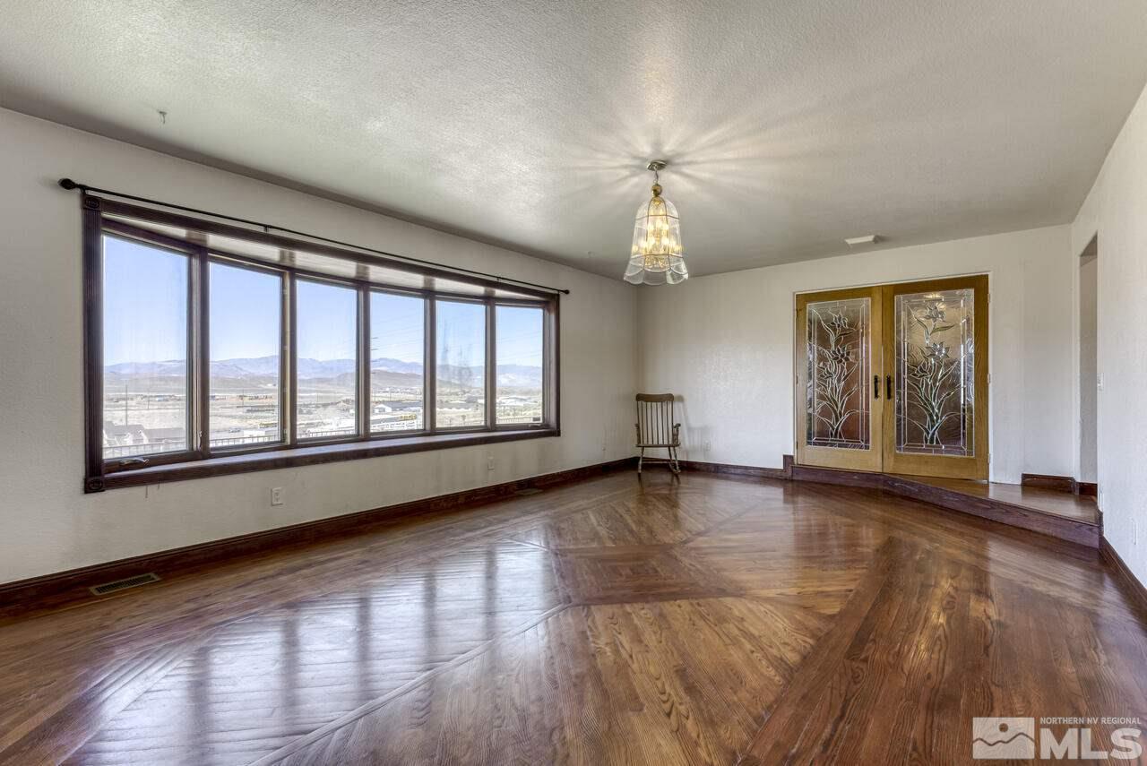 650 Desert Shadows Lane Fernley, NV 89408 - Photo 6 of 39 a view of an empty room with wooden floor and a window