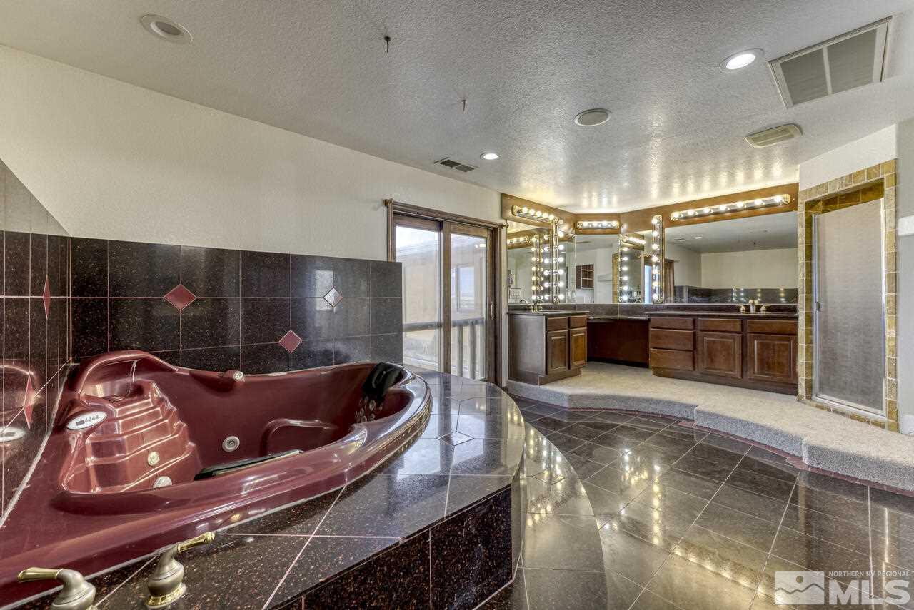 650 Desert Shadows Lane Fernley, NV 89408 - Photo 10 of 39 a kitchen with stainless steel appliances kitchen island granite countertop a refrigerator and a stove