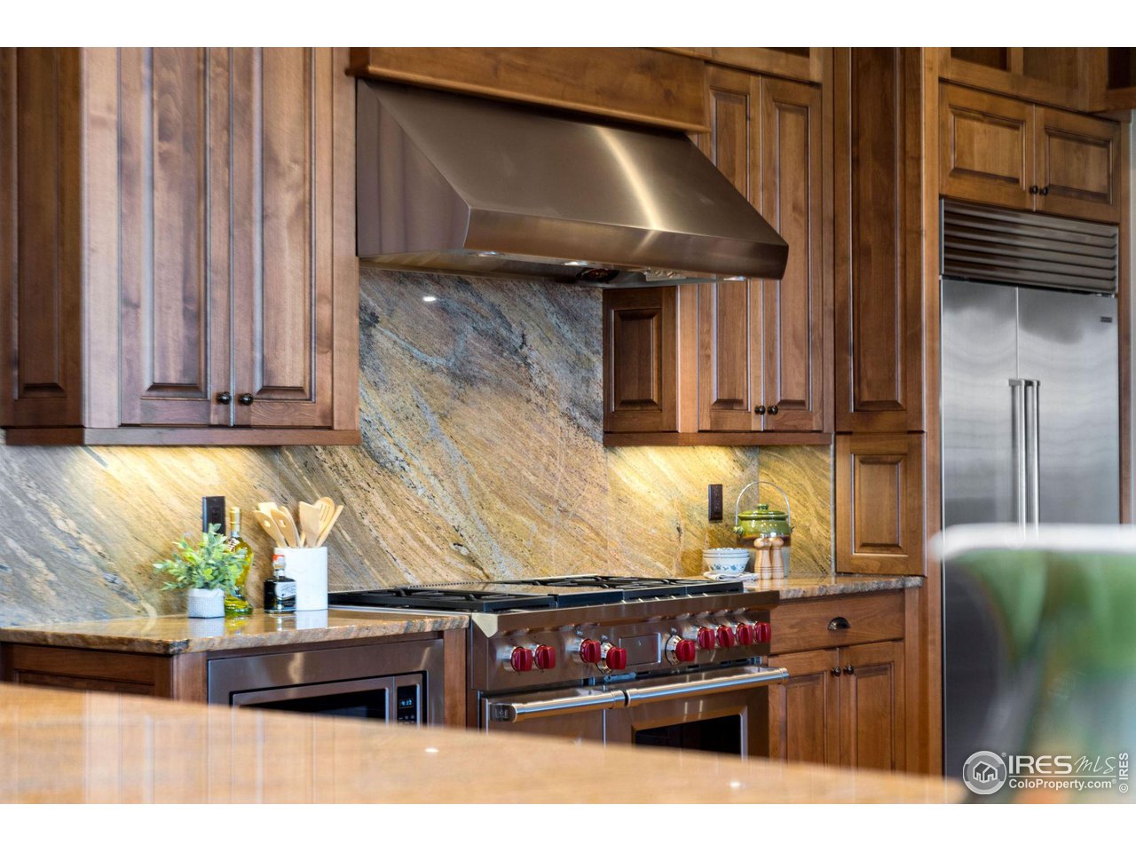39759 Pinnacle Ridge Court Severance, CO 80610 - Photo 14 of 40 a kitchen with stainless steel appliances kitchen island granite countertop a refrigerator