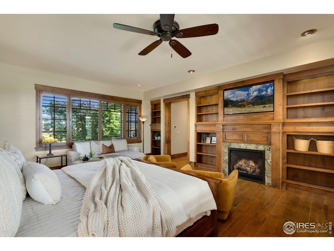 39759 Pinnacle Ridge Court Severance, CO 80610 - Photo 21 of 40 a bedroom with a large bed and a fireplace