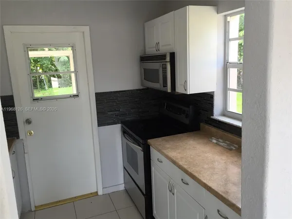 a kitchen with granite countertop a refrigerator and a stove