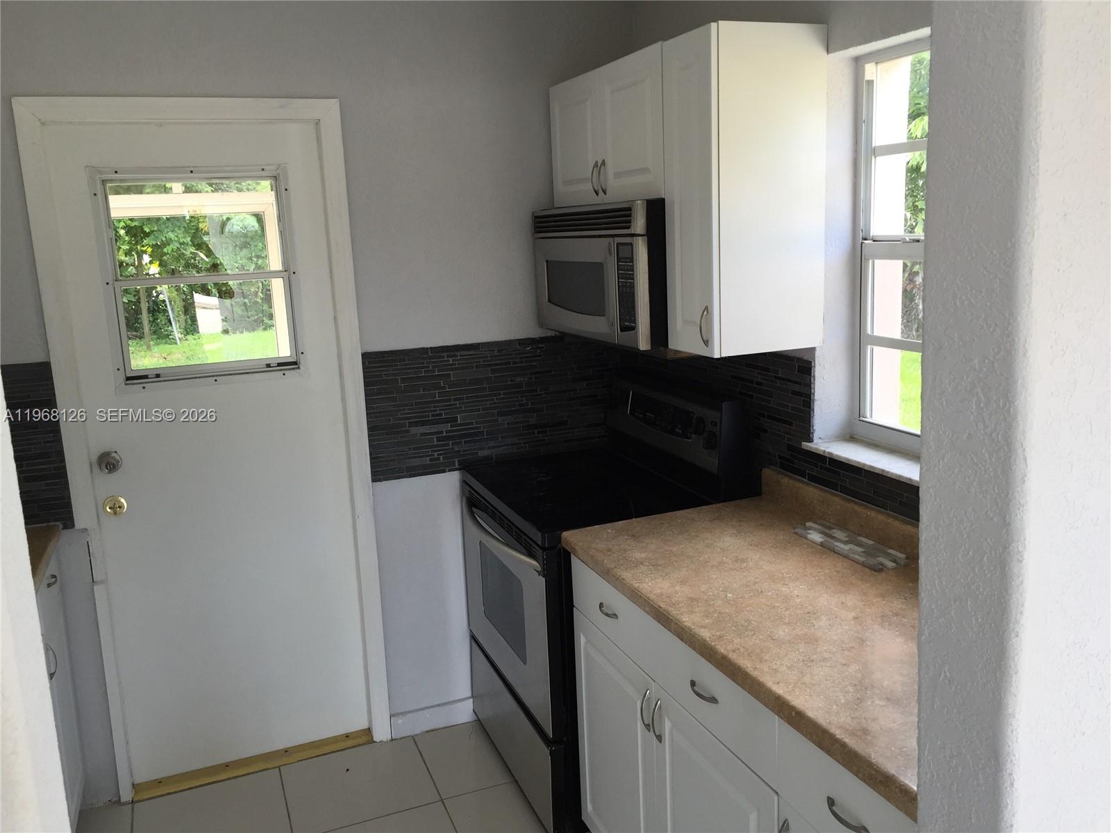 4700 Southwest 97th Avenue, Unit 4700 Miami, FL 33165 - Photo 4 of 9 a kitchen with granite countertop a refrigerator and a stove