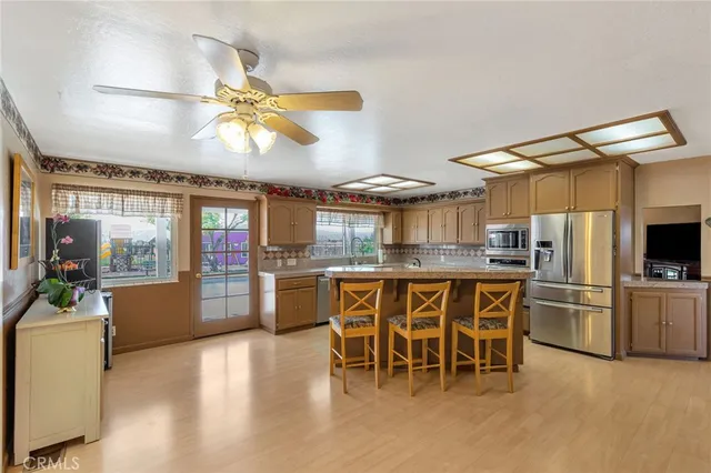 a kitchen with stainless steel appliances kitchen island granite countertop a table and chairs in it