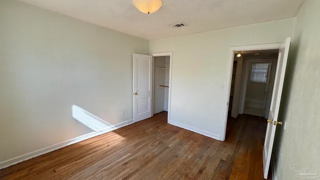 an empty room with wooden floor and closet
