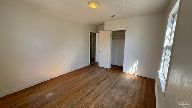 a view of an empty room with wooden floor