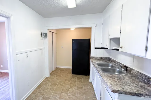 a kitchen with a refrigerator and a sink