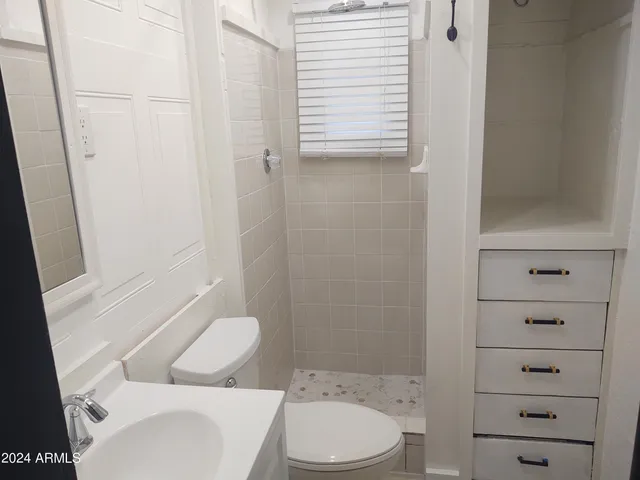 a white toilet sitting next to a bathroom sink