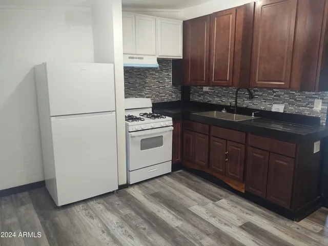a kitchen with sink a refrigerator and cabinets
