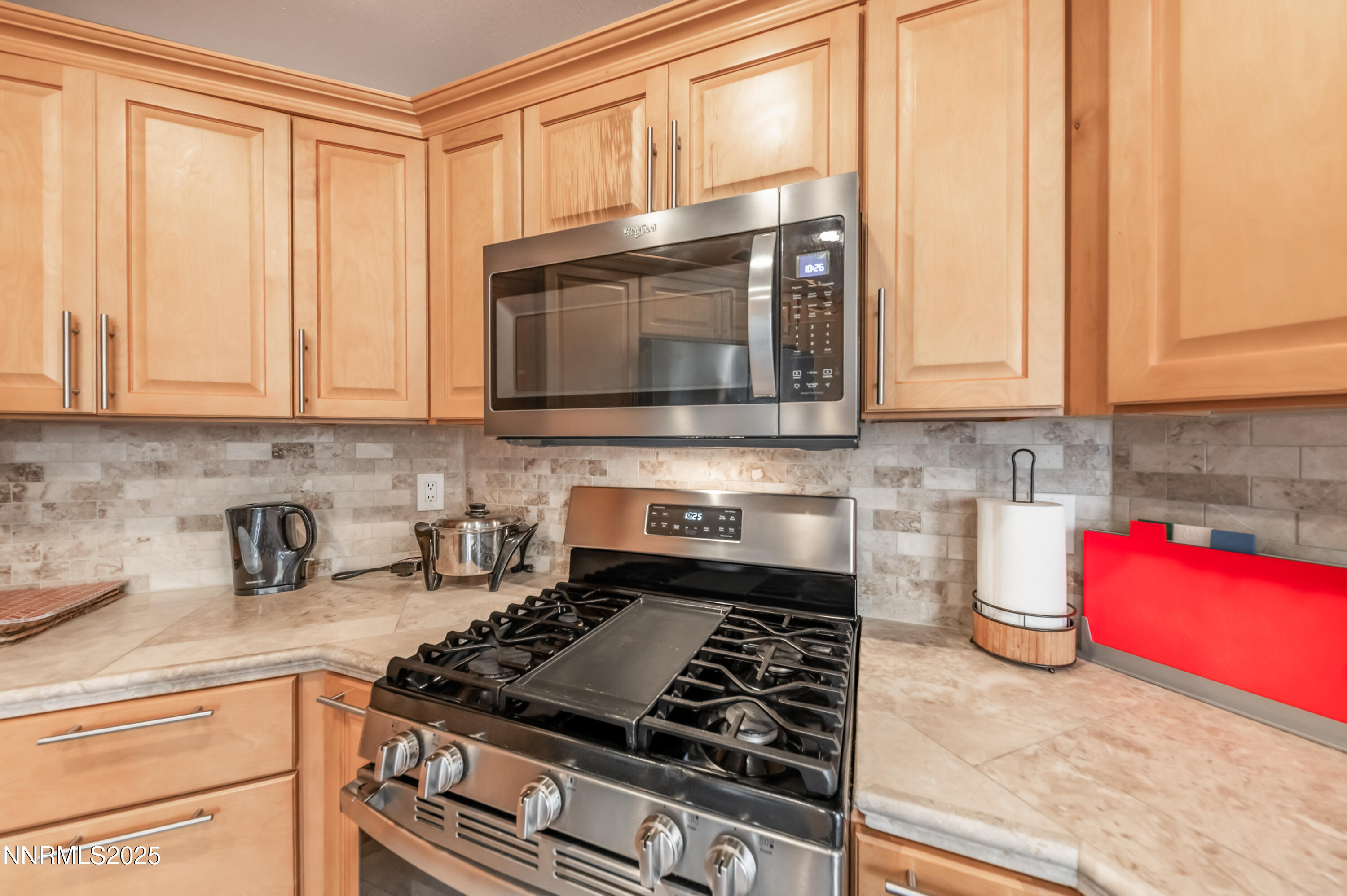5722 Golden Eagle Drive Reno, NV 89523 - Photo 11 of 32 a kitchen with granite countertop a stove top oven microwave and cabinets