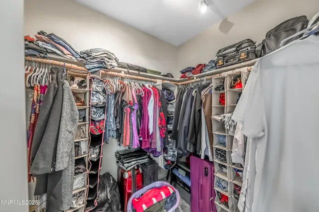 a view of walk in closet with clothes