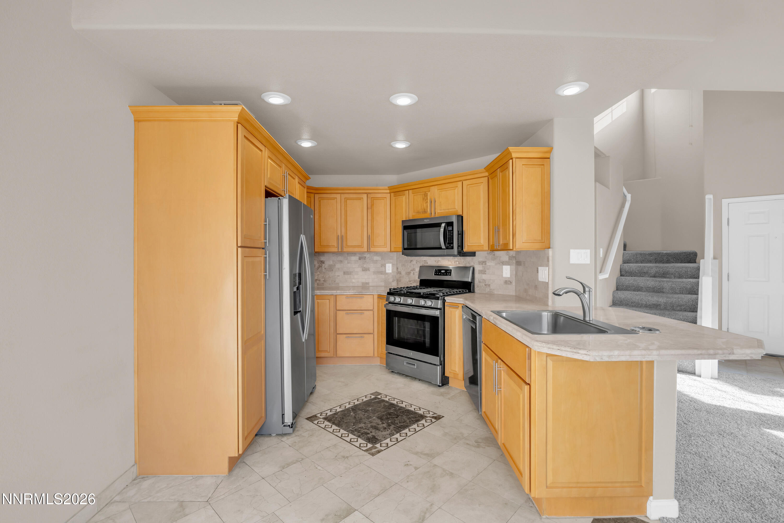 5722 Golden Eagle Drive Reno, NV 89523 - Photo 2 of 5 a kitchen with stainless steel appliances granite countertop a sink a stove a refrigerator and a refrigerator