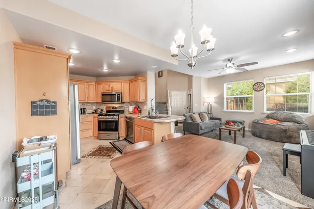 a kitchen with sink refrigerator dining table and chairs