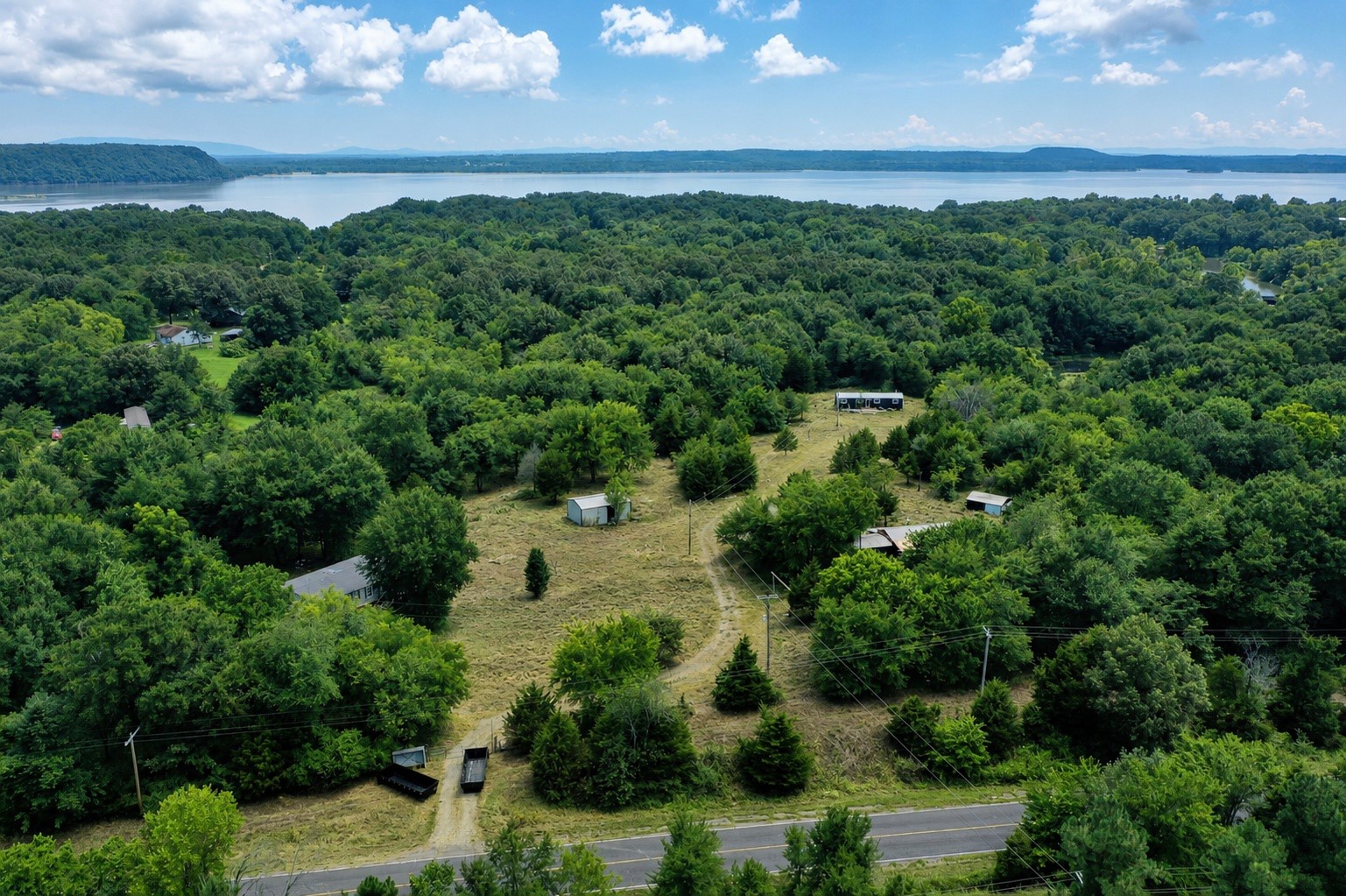 461924 East 1140 Road Sallisaw, OK 74955 - Photo 28 of 29 Expansive treed landscape with multiple structures, cleared areas, and a visible body of water in the distance