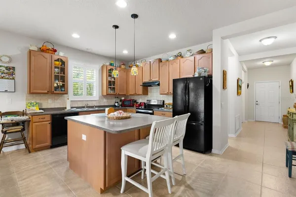 a kitchen with a refrigerator a sink dishwasher with a dining table and chairs