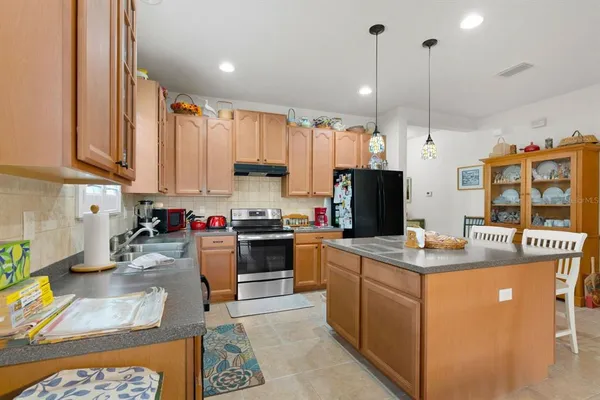 a kitchen that has a lot of cabinets a sink and appliances in it