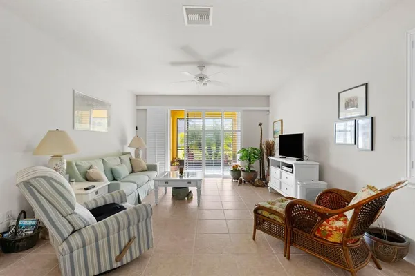 a living room with furniture a ceiling fan and a flat screen tv