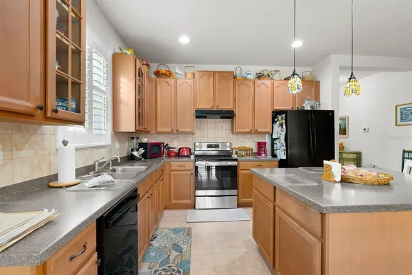 a kitchen with stainless steel appliances granite countertop a sink refrigerator and cabinets