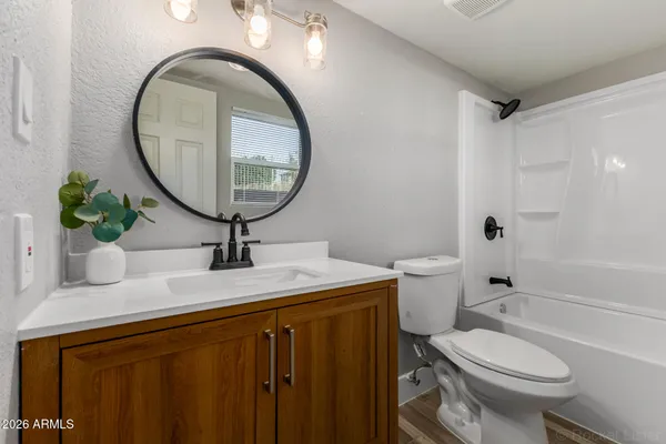 a bathroom with a granite countertop toilet a sink and a mirror