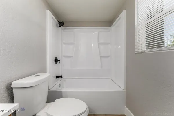 a bathroom with a toilet and a bath tub