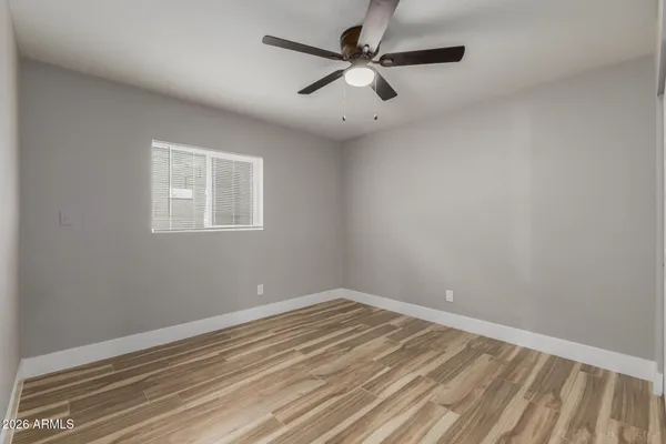 an empty room with a window and a fan