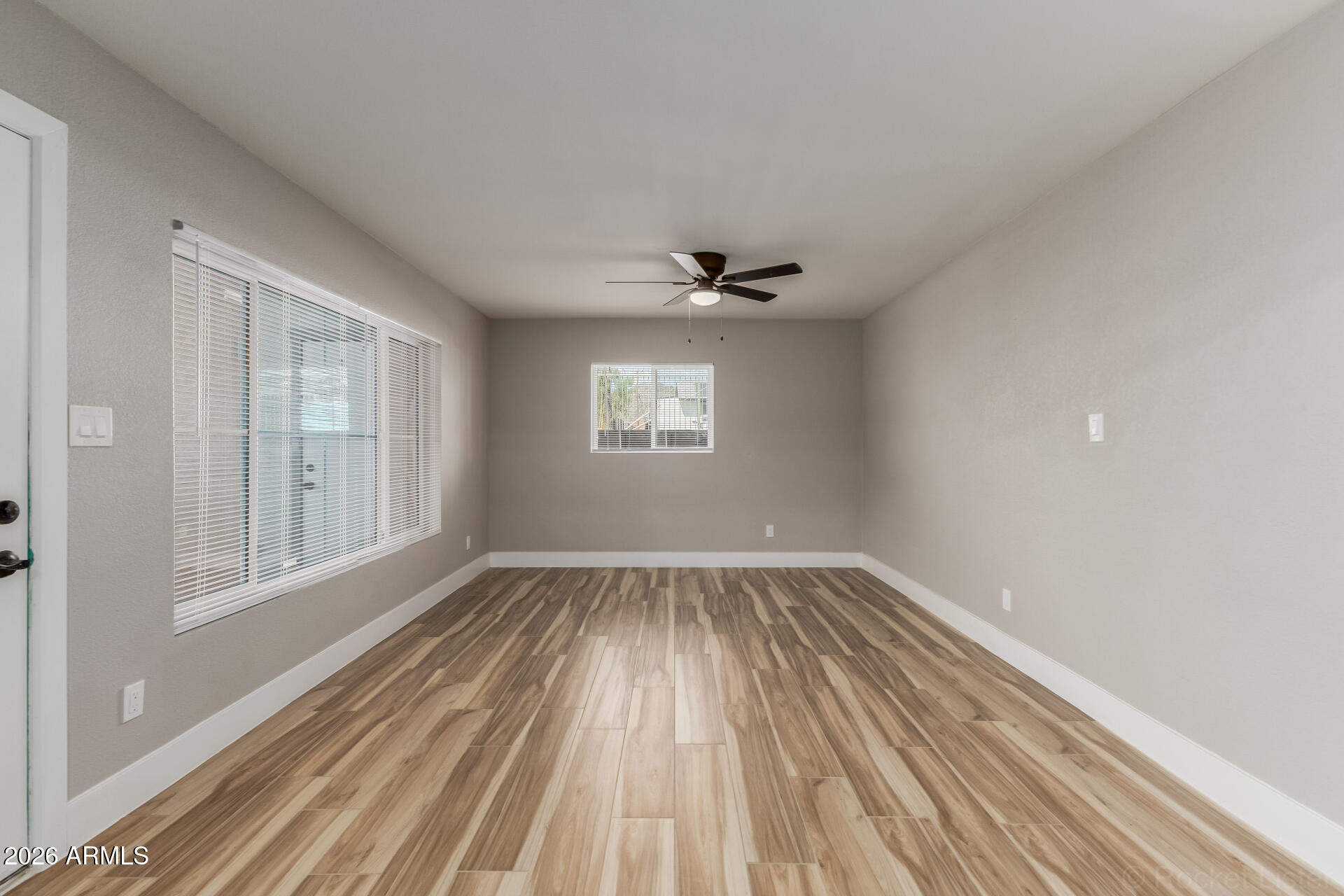 214 East Ruth Avenue, Unit 109 Phoenix, AZ 85020 - Photo 3 of 26 a view of an empty room with wooden floor and a window