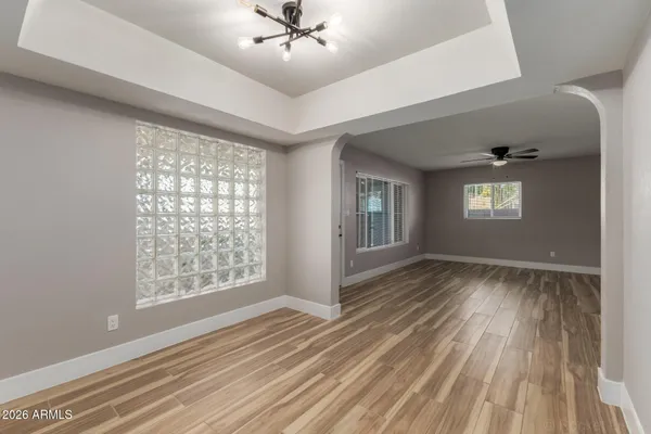 a view of an empty room with window and wooden floor