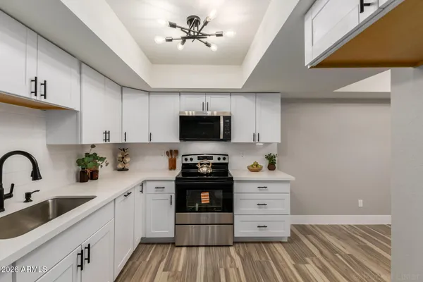 a kitchen with appliances a sink and cabinets