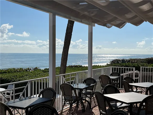 a dining room with furniture potted plants and wooden floor