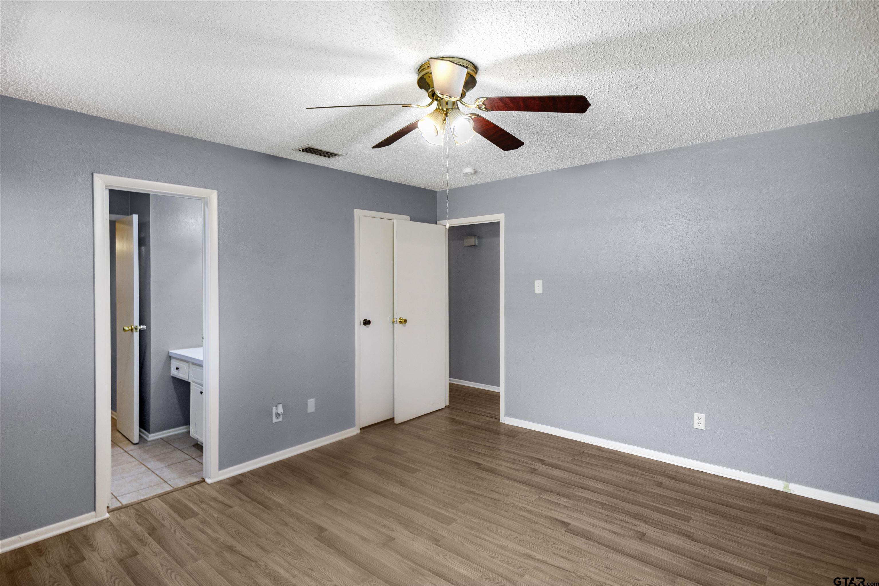 206 Walter Street Longview, TX 75603 - Photo 14 of 17 a view of an empty room with wooden floor and a ceiling fan