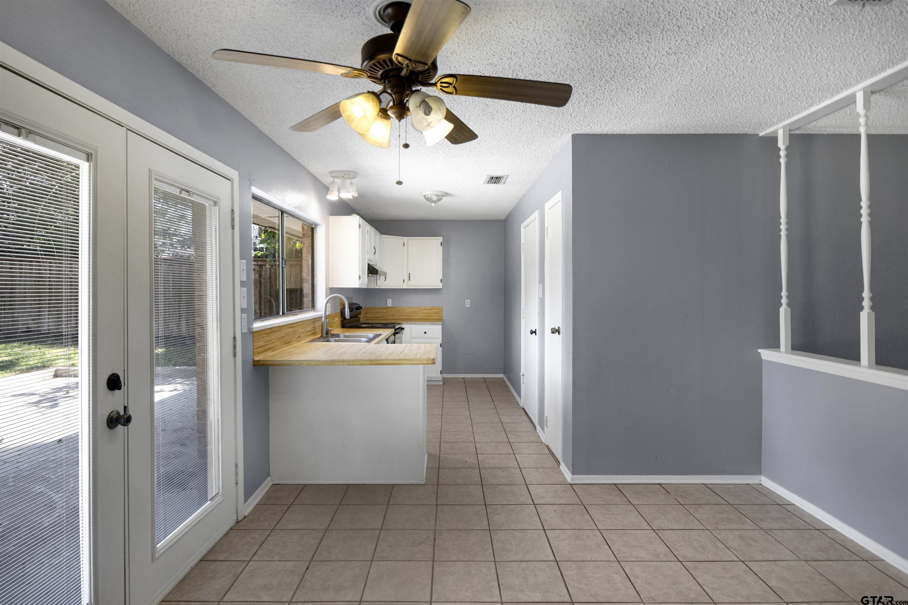 206 Walter Street Longview, TX 75603 - Photo 4 of 17 a view of a kitchen with a sink and a refrigerator