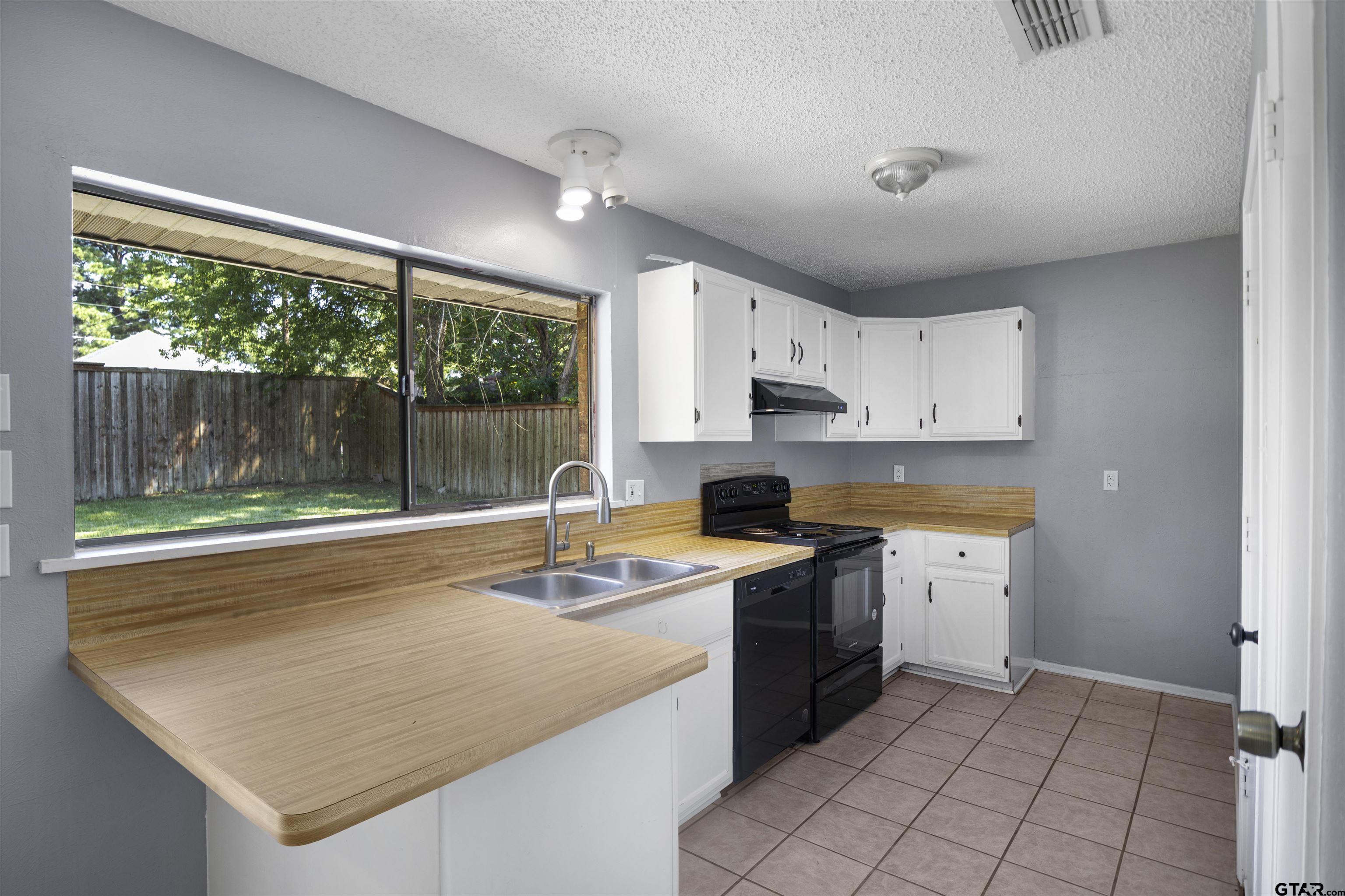 206 Walter Street Longview, TX 75603 - Photo 5 of 17 a kitchen with a sink stove and cabinets