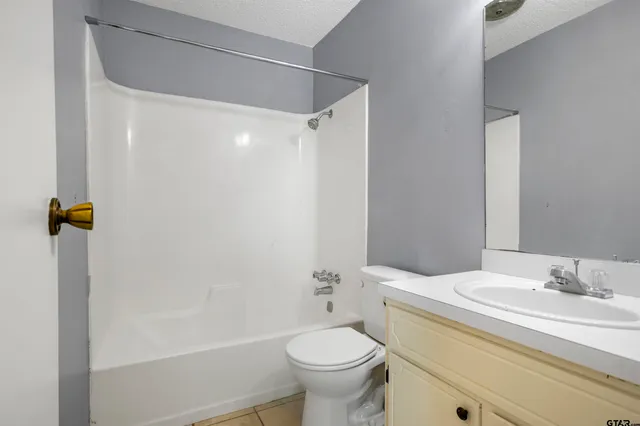 a bathroom with a granite countertop sink a toilet and shower