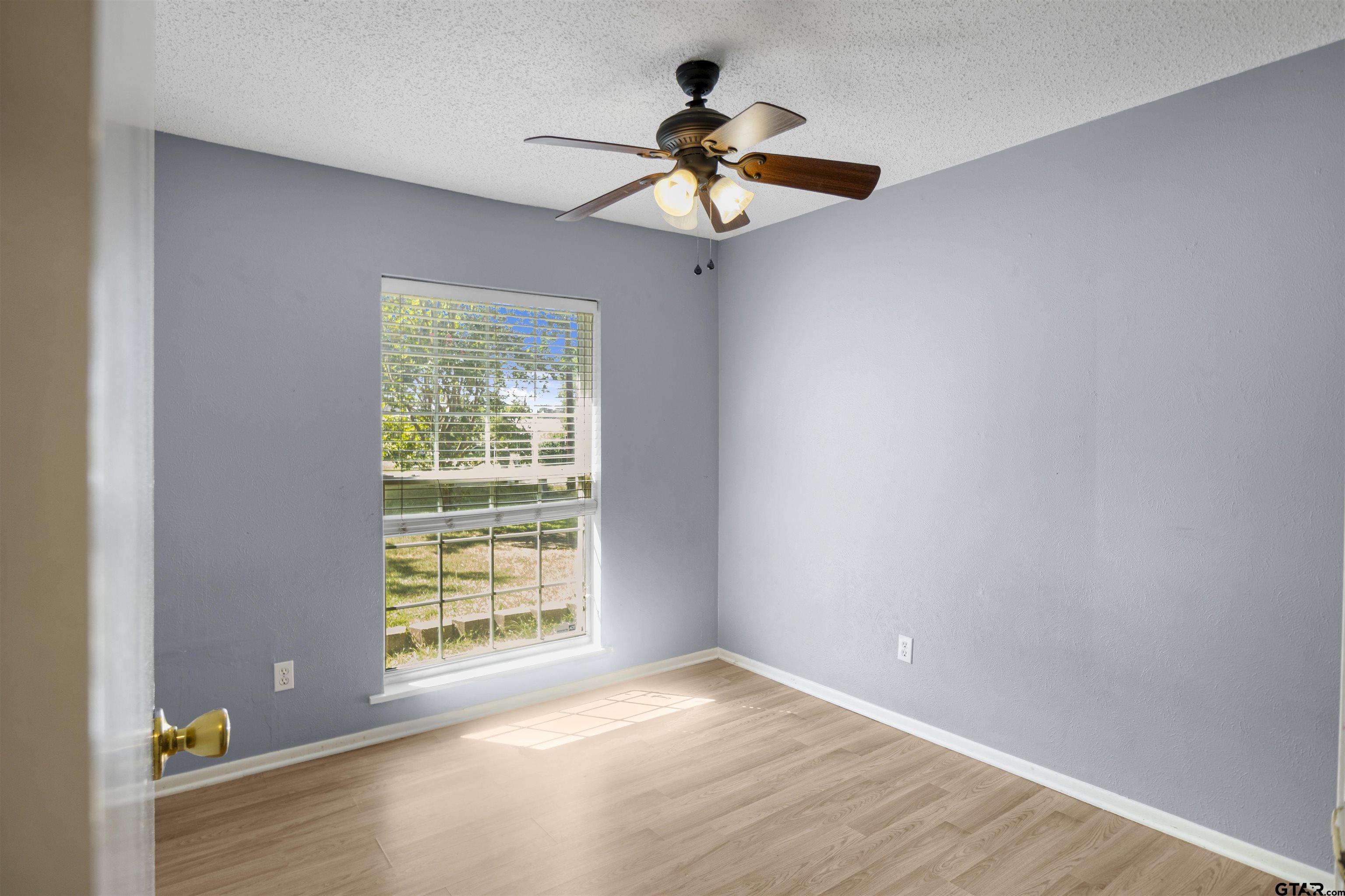 206 Walter Street Longview, TX 75603 - Photo 9 of 17 a view of an empty room with wooden floor and a window