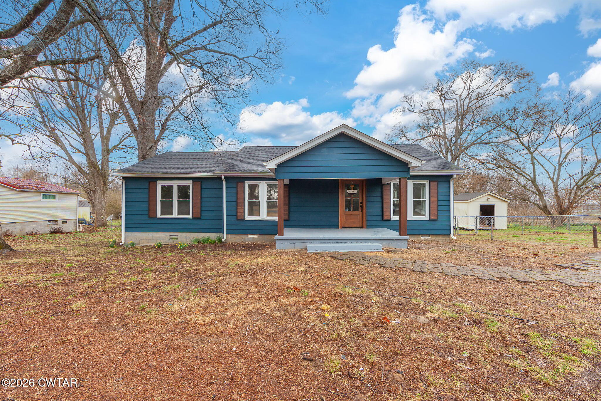 a view of a yard in front of a house with large trees