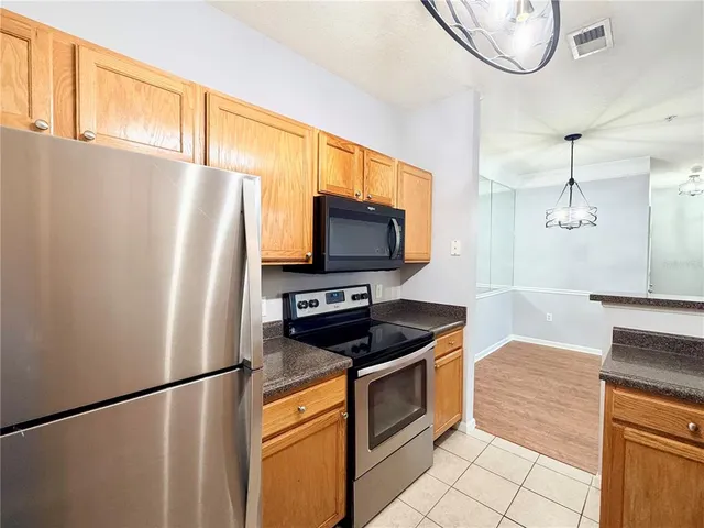 an empty room with wooden floor ceiling fan and windows